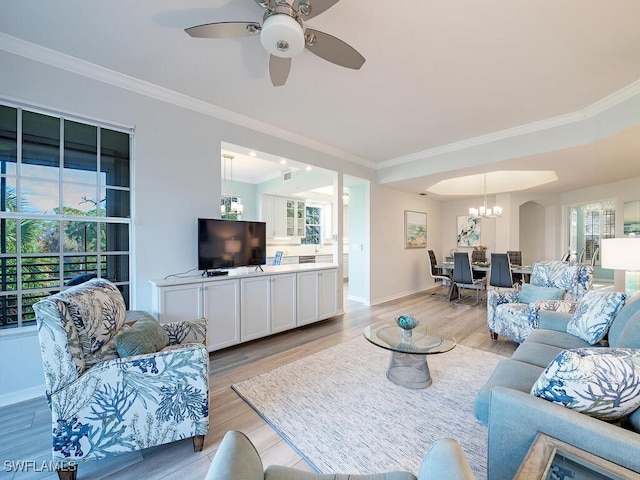 living room featuring ornamental molding, ceiling fan with notable chandelier, and light hardwood / wood-style floors