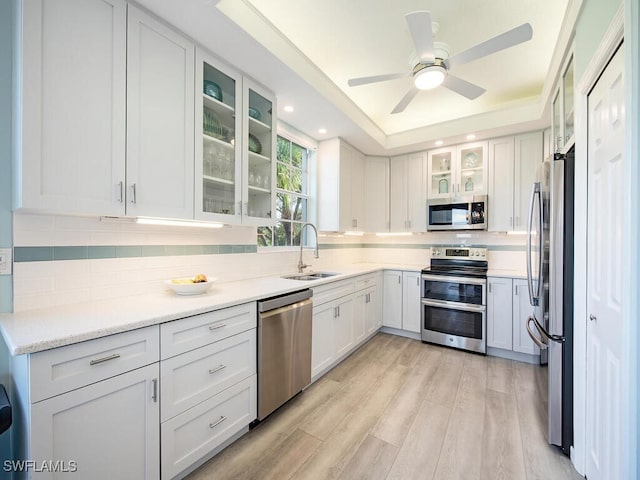 kitchen featuring sink, decorative backsplash, stainless steel appliances, and white cabinets