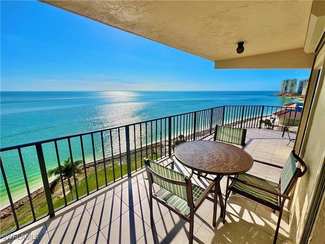 balcony featuring a water view and a beach view