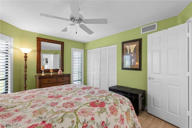 bedroom with light hardwood / wood-style flooring, a closet, and ceiling fan