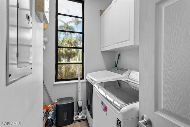 651 10th Ave S Unit C-651, Naples, FL 34102 - washroom featuring baseboards, cabinet space, wood finished floors, and washing machine and clothes dryer