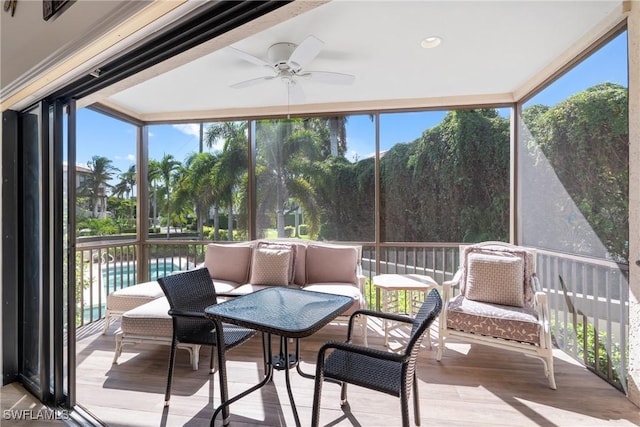 sunroom / solarium featuring a water view, a healthy amount of sunlight, and ceiling fan