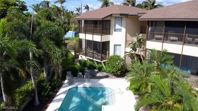 view of swimming pool with a patio and a sunroom