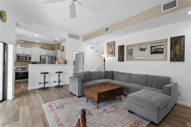 living room featuring ceiling fan and light hardwood / wood-style flooring