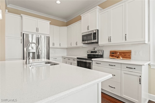 kitchen with stainless steel appliances, white cabinetry, and ornamental molding