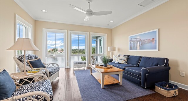 sitting room featuring dark hardwood / wood-style flooring, ornamental molding, ceiling fan, and a healthy amount of sunlight