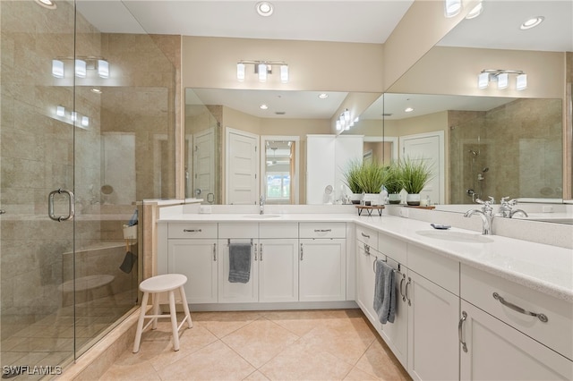 bathroom with an enclosed shower, vanity, and tile patterned floors