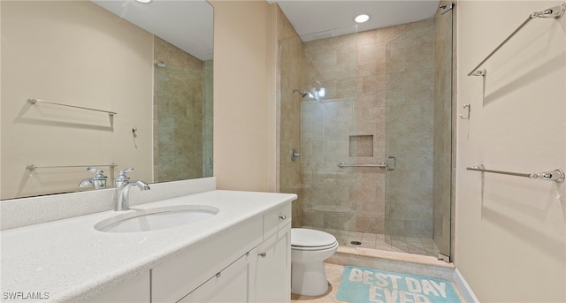 bathroom with a shower with shower door, vanity, toilet, and tile patterned flooring