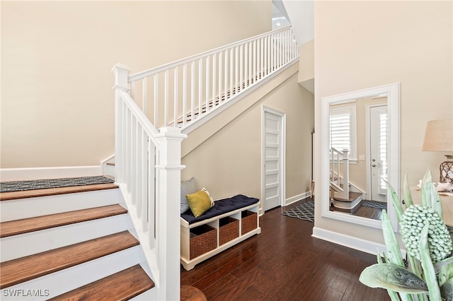 staircase featuring a high ceiling and hardwood / wood-style floors