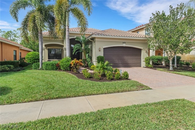 mediterranean / spanish house featuring a front lawn and a garage