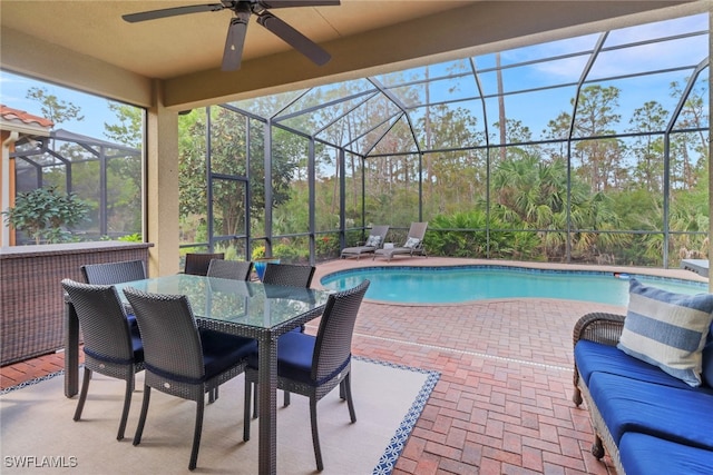 view of swimming pool featuring a patio area, ceiling fan, and glass enclosure