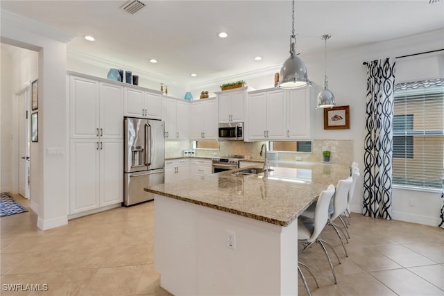 kitchen featuring a kitchen breakfast bar, kitchen peninsula, decorative light fixtures, white cabinets, and appliances with stainless steel finishes