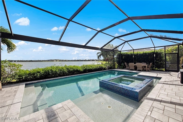 view of pool with an in ground hot tub, a water view, glass enclosure, and a patio area