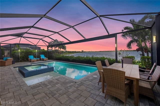 pool at dusk with a patio area, a water view, an in ground hot tub, and a lanai