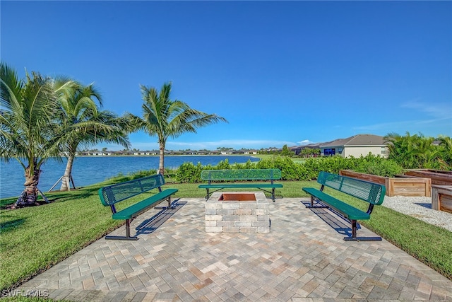 view of community featuring a yard, a patio, and a water view