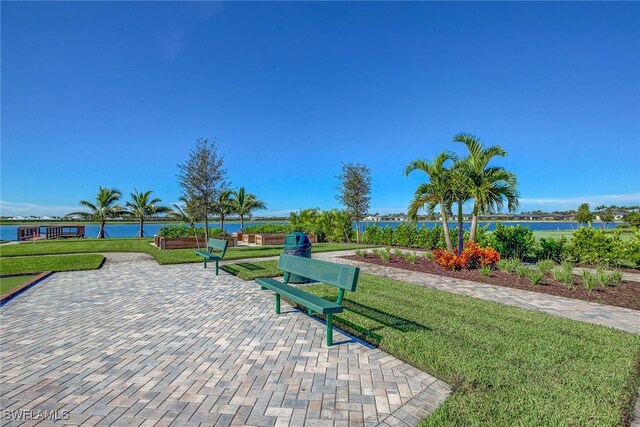 view of community with a yard and a water view