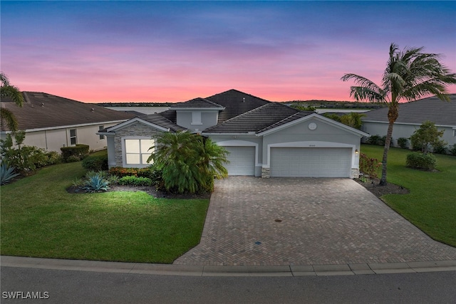 single story home featuring a yard and a garage