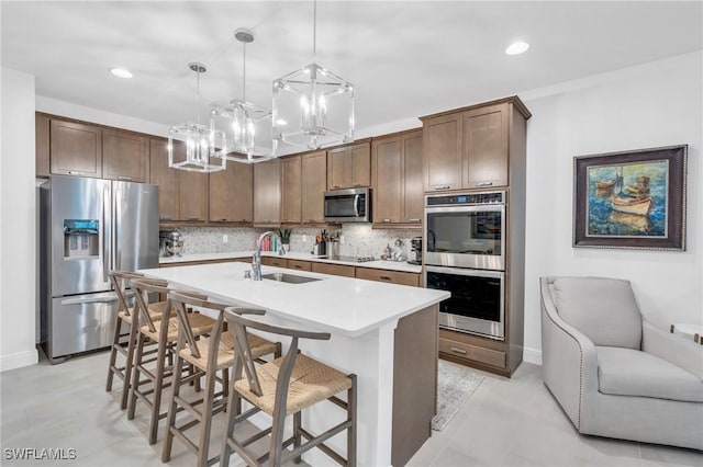 26506 Bonita Fairways Blvd, Bonita Springs, FL 34135 - kitchen with stainless steel appliances, a sink, light countertops, backsplash, and a chandelier