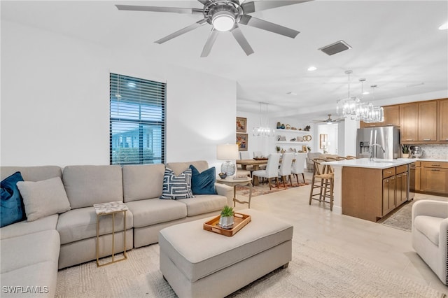 tiled living room with ceiling fan with notable chandelier and sink