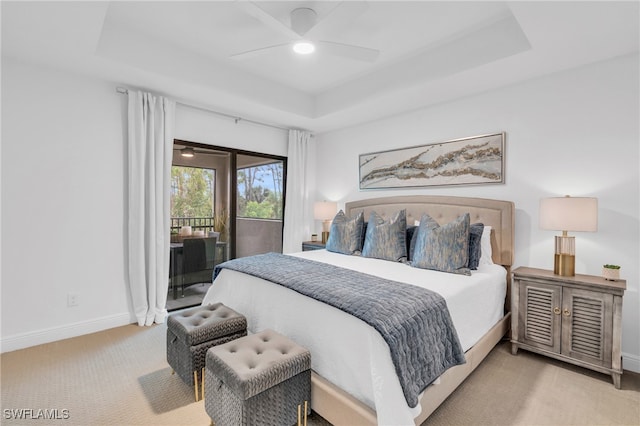 bedroom featuring ceiling fan, light carpet, a raised ceiling, and access to outside