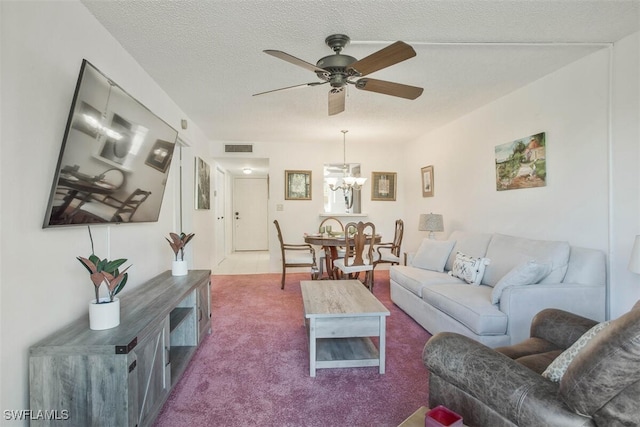 carpeted living room with ceiling fan with notable chandelier and a textured ceiling