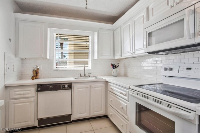 kitchen featuring white cabinetry, sink, light tile patterned floors, and white appliances