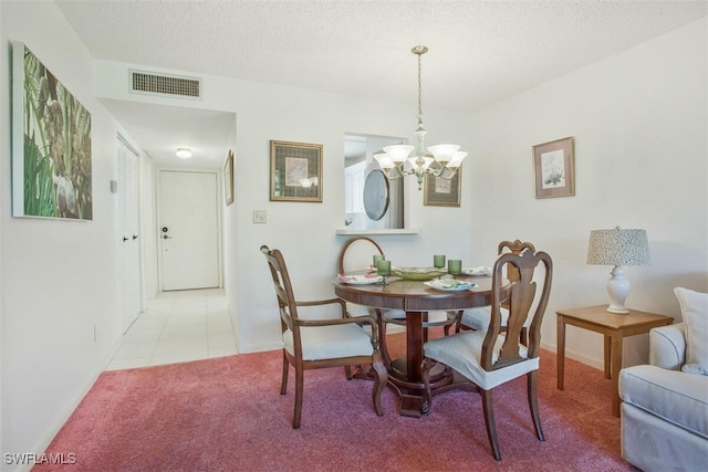 dining area featuring a textured ceiling, a notable chandelier, and light carpet