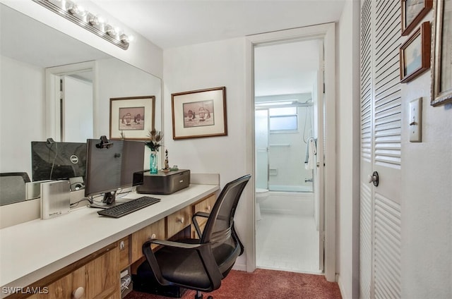 carpeted home office featuring built in desk