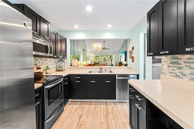 kitchen featuring sink, appliances with stainless steel finishes, backsplash, light hardwood / wood-style flooring, and lofted ceiling