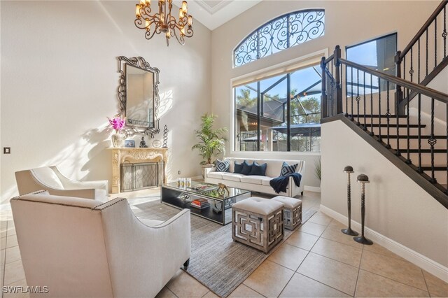 living room featuring a notable chandelier, light tile patterned floors, a high ceiling, and a high end fireplace