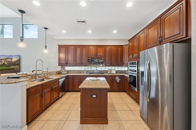 kitchen with light stone counters, stainless steel appliances, sink, a center island, and hanging light fixtures