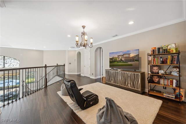 living room featuring a chandelier, dark hardwood / wood-style flooring, and crown molding