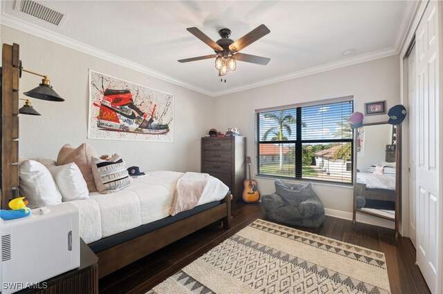 bedroom featuring dark hardwood / wood-style flooring, ceiling fan, and ornamental molding