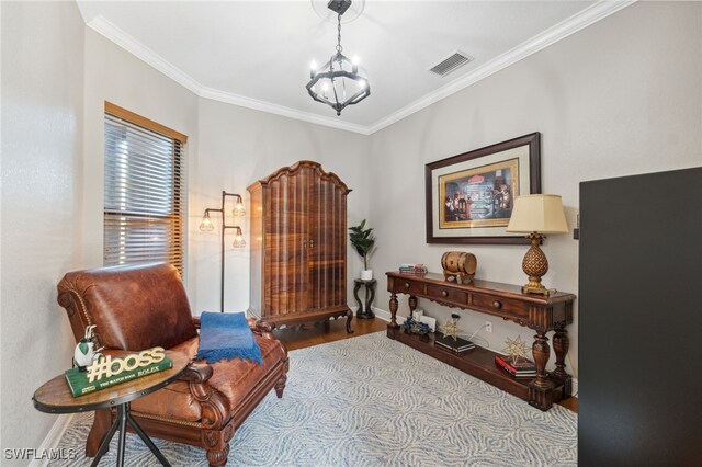 living area featuring a notable chandelier, light hardwood / wood-style floors, and crown molding