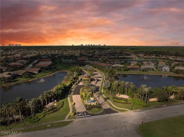 aerial view at dusk featuring a water view