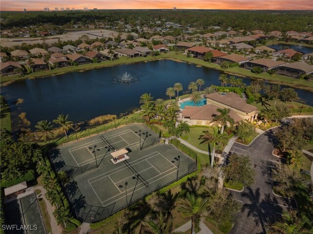 aerial view at dusk featuring a water view