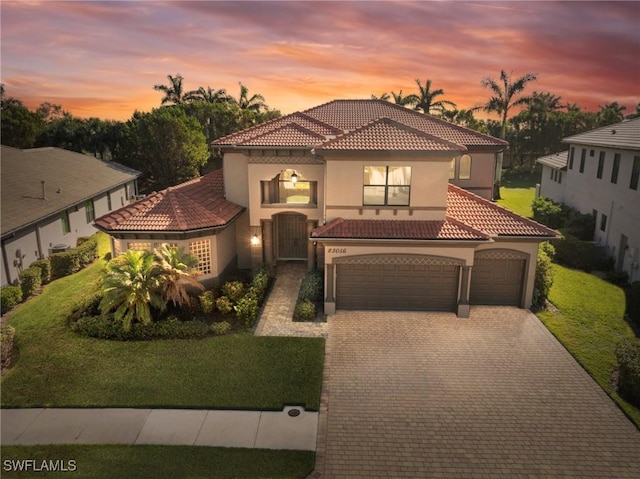 mediterranean / spanish-style home featuring a lawn and a garage