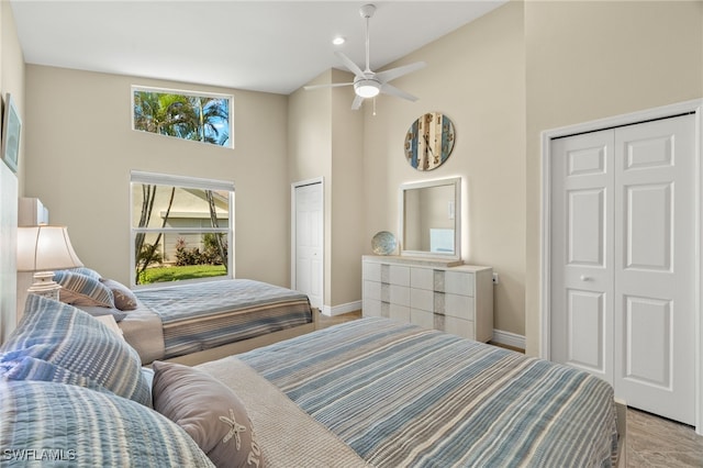 bedroom with a high ceiling and baseboards