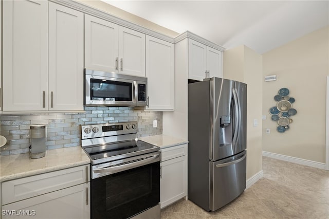 kitchen featuring light tile patterned floors, baseboards, appliances with stainless steel finishes, light stone countertops, and backsplash