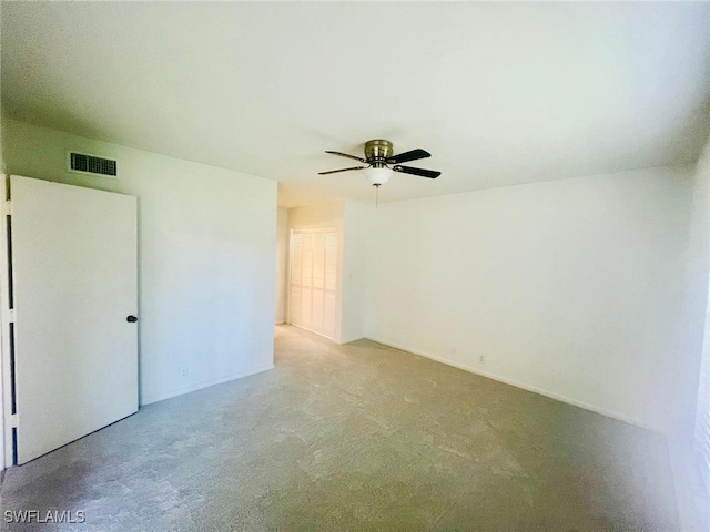 unfurnished room with visible vents, ceiling fan, and light carpet