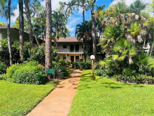 view of front of home featuring a front lawn and a balcony