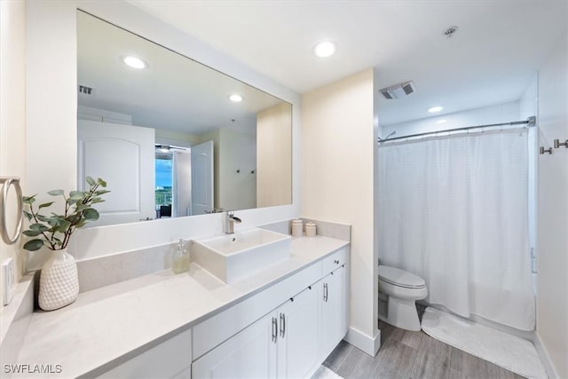 bathroom featuring toilet, vanity, hardwood / wood-style flooring, and a shower with shower curtain