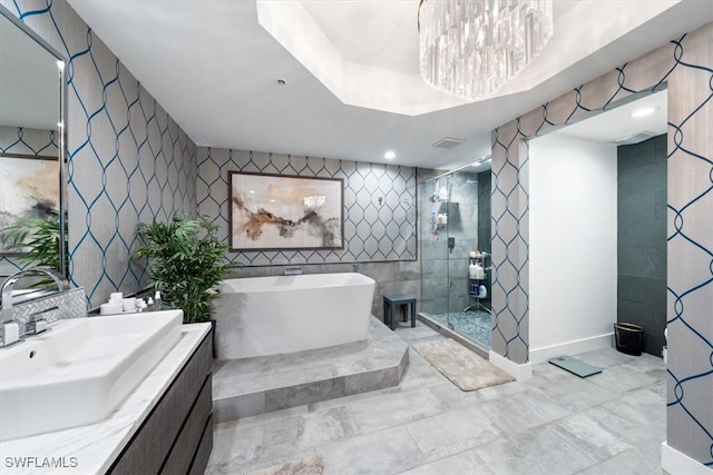 bathroom featuring tile walls, vanity, plus walk in shower, and an inviting chandelier