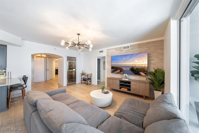 living room featuring light wood-type flooring and an inviting chandelier