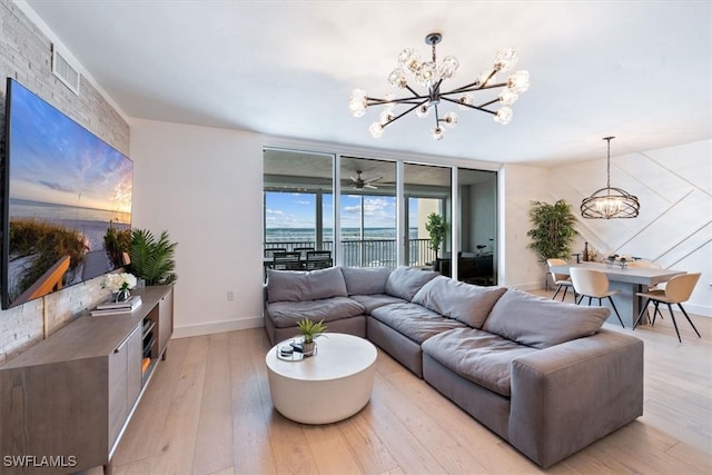 living room with a notable chandelier and light hardwood / wood-style floors