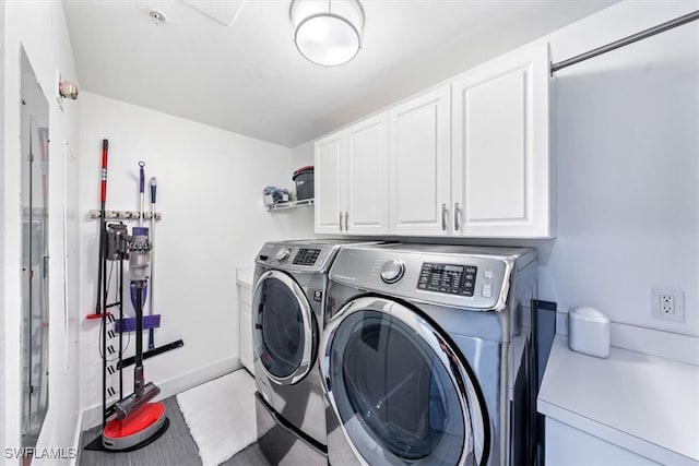 laundry room featuring washer and clothes dryer and cabinets