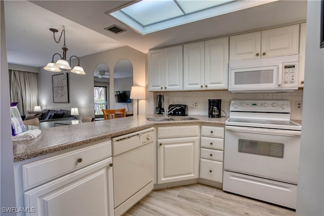 kitchen with white cabinetry, backsplash, white appliances, and a notable chandelier