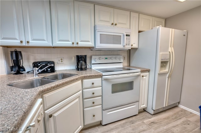 kitchen featuring white cabinets, sink, backsplash, light wood-type flooring, and white appliances