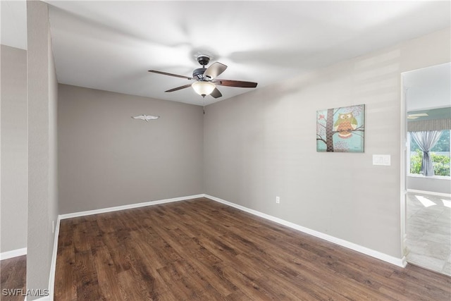 spare room featuring ceiling fan and dark wood-type flooring