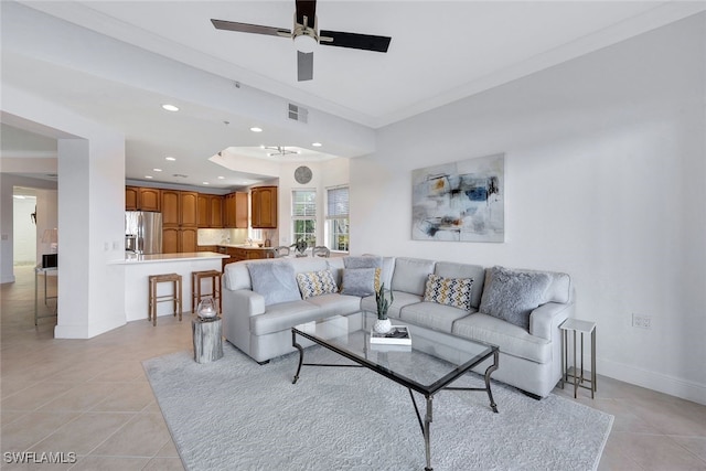 tiled living room featuring ceiling fan and crown molding